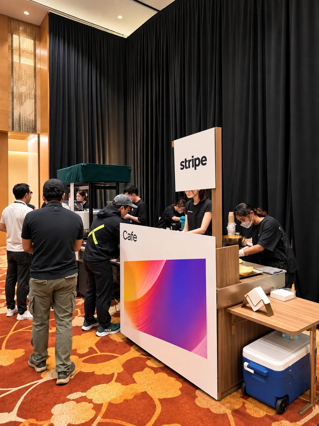 The Genista Ln kopi cart dressed in Stripe branding at a hotel ballroom activation, with baristas serving from behind a custom-printed counter.