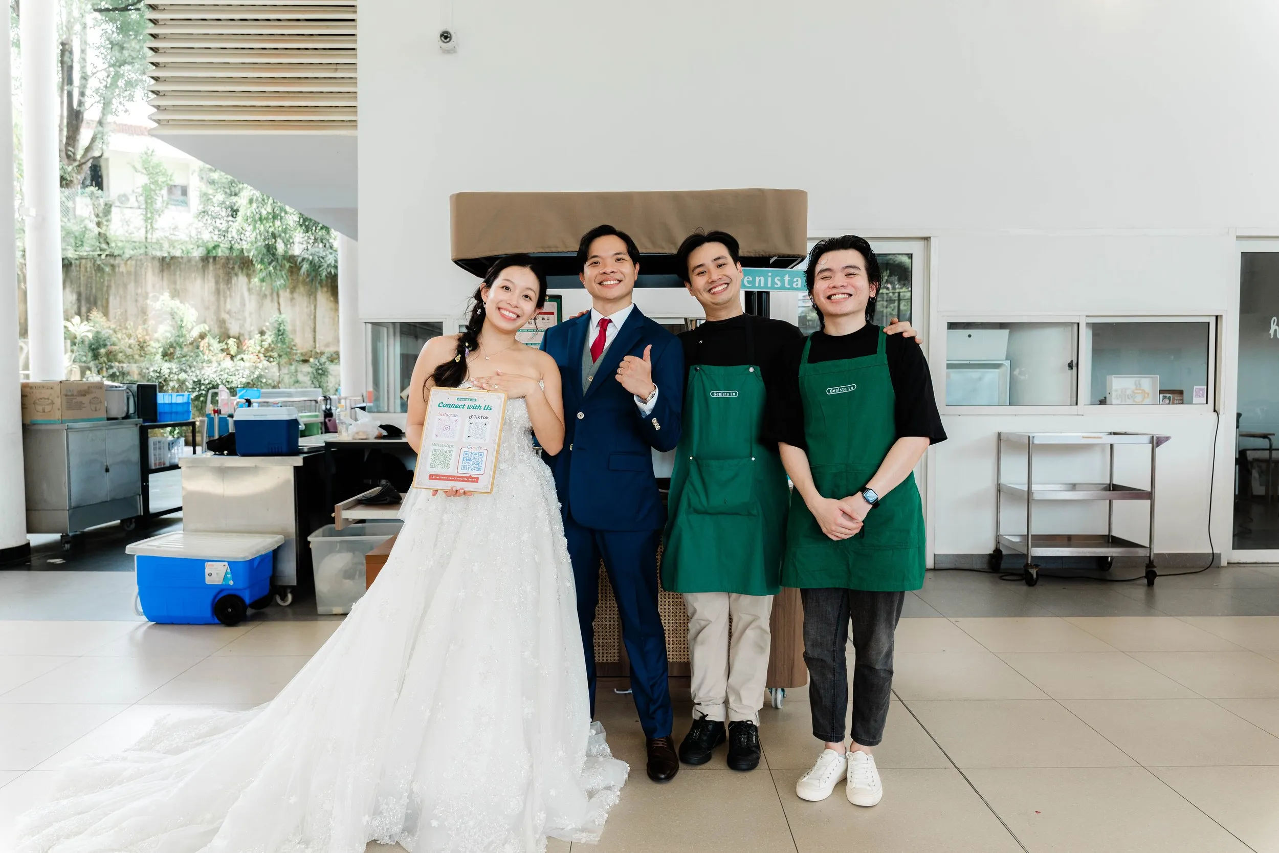Mark and Rachel standing with two Genista Ln crew beside the kopi cart at their church wedding
