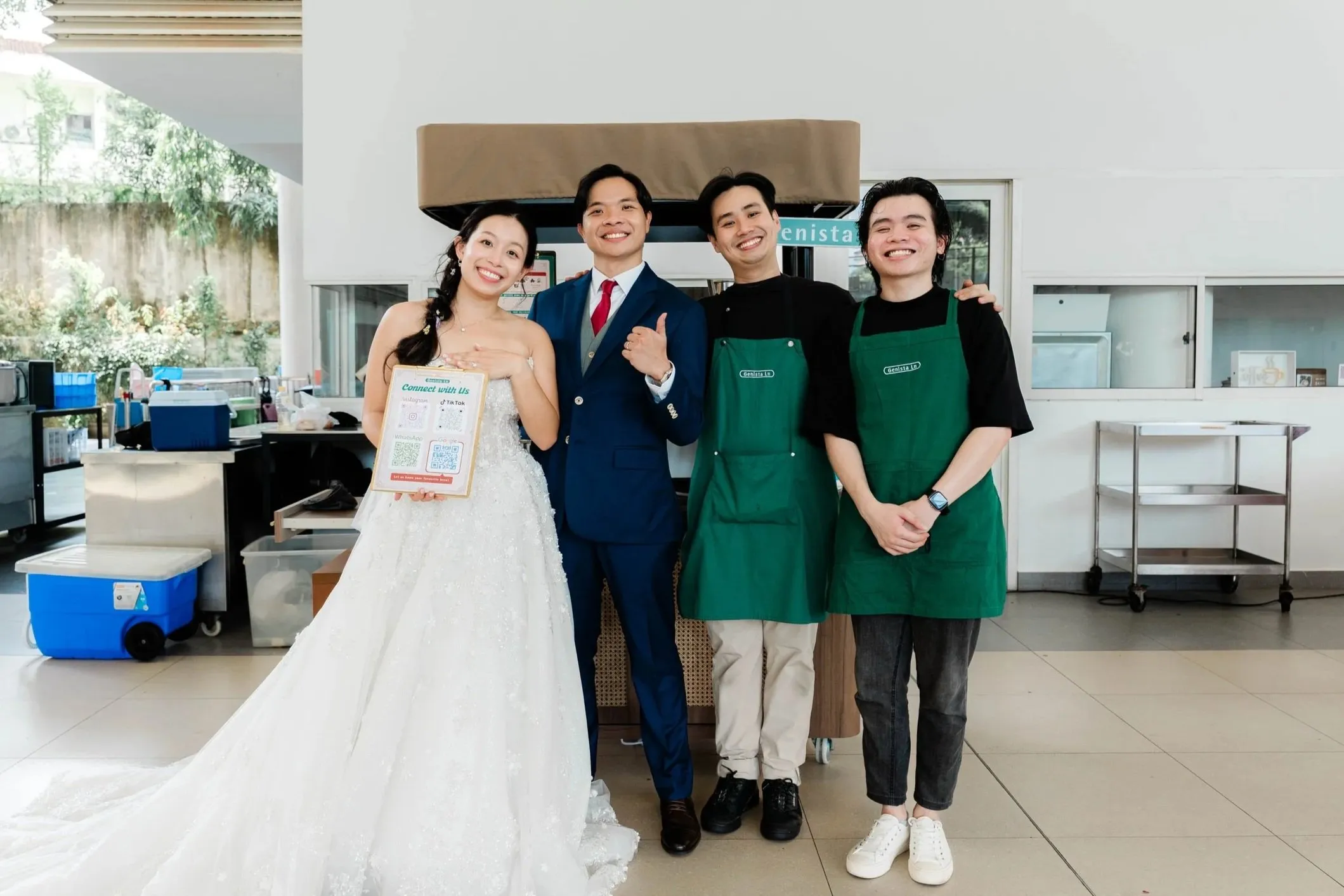 Mark and Rachel smiling with two Genista Ln crew members beside the kopi cart at their church wedding